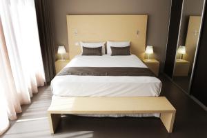 - une chambre avec un grand lit et deux lampes dans l'établissement Hôtel du Centre, à Nouméa