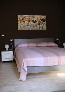 1 dormitorio con 1 cama y una pintura en la pared en Sapigno B&B, en SantʼAgata Feltria