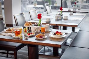 einen Tisch mit Frühstückszutaten und Getränken darauf in der Unterkunft Lindner Hotel Nurburgring Motorsport, part of JdV by Hyatt in Nürburg