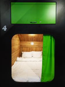 Kapsuła Hostel في زاتور: تلفزيون بشاشة مسطحة فوق سرير في الغرفة