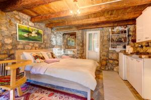 a bedroom with a bed and a stone wall at Holiday Home Pavle in Rijeka Crnojevića