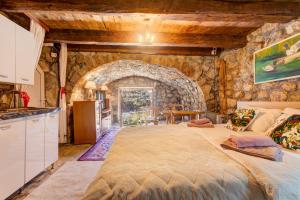 a large bed in a room with a stone wall at Holiday Home Pavle in Rijeka Crnojevića