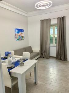 ein Wohnzimmer mit einem Tisch und einem Sofa in der Unterkunft Villa Maria appartamento Ischia in Monte di Procida
