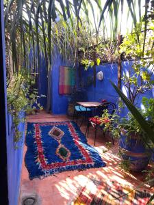 a blue room with a table and a rug at Riad Alamine in Marrakesh