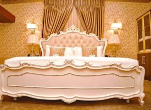 a large white bed with a large headboard in a bedroom at NO.1 HOTEL in Abuja