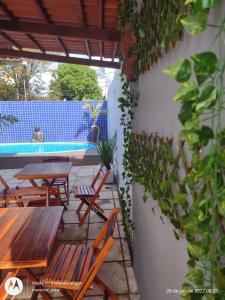un patio con mesas y sillas junto a una piscina en Blue Hostel, en Natal