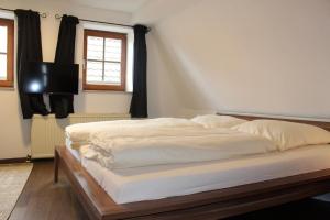 a large bed in a bedroom with a television at Gästehaus Anker in Dinkelsbühl +4 photos