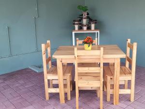 een houten tafel en stoelen met een plant erop bij 7 On Strauss in Beaufort West