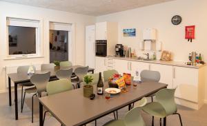 eine Küche und ein Esszimmer mit Tischen und Stühlen in der Unterkunft Den Gode Søvn in Øster Hurup