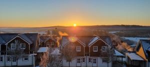 a group of houses with the sunset in the background at Nürburgring Ferienpark in Nürburg