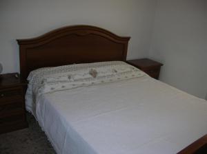 una camera con letto e testiera in legno di Appartamento orlando vista panoramica Pomonte isola D'Elba a Pomonte