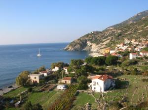 a small town on a hill next to the ocean at Appartamento orlando vista panoramica Pomonte isola D'Elba in Pomonte