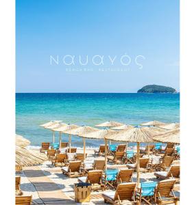 a beach with chairs and umbrellas and the ocean at Villa Nickolas in Paleo Tsifliki