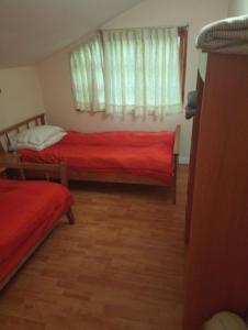 1 dormitorio con 2 camas y ventana en Omi Kika B&B, en Villarrica