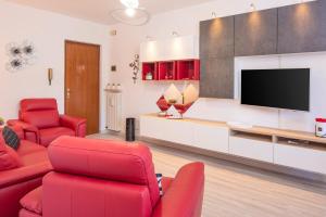 een woonkamer met rode meubels en een flatscreen-tv bij CASA POPPEA in Bardolino