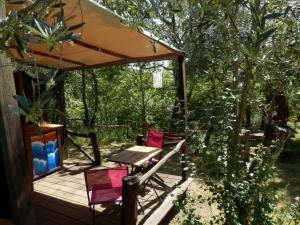 una terraza de madera con 2 sillas y una mesa en Green Man yurt, en Penela