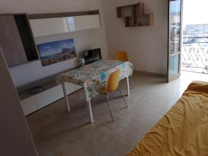 a room with a table with chairs and a television at casa torre di ligny in Trapani