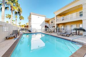 a swimming pool with chairs and a building at Sea Glass Condominiums #9 in South Padre Island