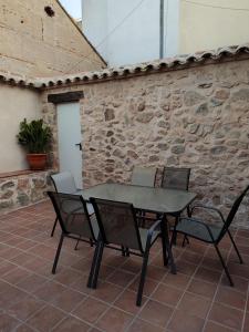 a table and chairs on a patio with a stone wall at Casa Bruna in Cobisa +6 photos