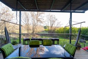un patio con mesa y sillas en una terraza en צימרים בצפון - עץ נוי en Sheʼar Yashuv