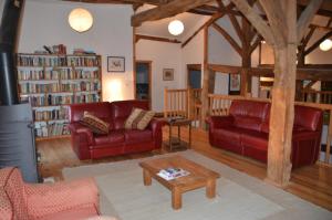 a living room with red couches and a coffee table at Katy's Barn in Saint-Aulaye