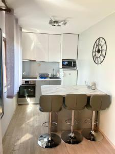 a kitchen with a table and two bar stools at Apartment Stella in Mali Lošinj