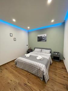sypialnia z dużym łóżkiem w niebieskim pasku w obiekcie Pozzuoli B&B exSofer w mieście Pozzuoli