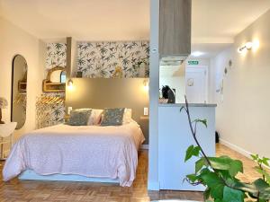 a bedroom with a large bed and a kitchen at Puerta al cielo Suite in Burgos