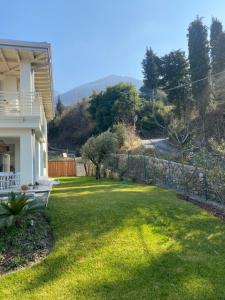 a yard with a fence in front of a house at Verdolivo in Sale Marasino