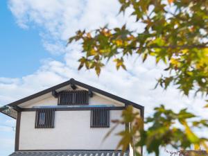 a white building with black windows on top of it at Guest House Wakabaya in Takamatsu