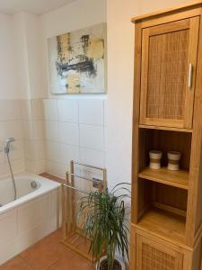 ein Badezimmer mit einer Badewanne und einer Pflanze darin in der Unterkunft Altstadt Ferienwohnung in Brandenburg an der Havel