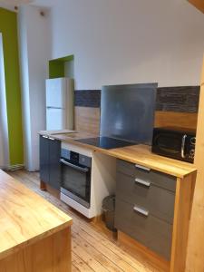 a kitchen with a counter top with a microwave at Bourgueil - Grand appartement proche CNPE Chinon in Bourgueil +5 photos
