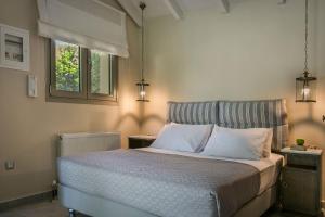 a bedroom with a bed with white pillows and a window at Fanari House in Argostoli