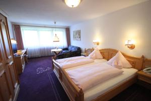 a bedroom with two beds and a living room at IMbery Hotel & Restaurant Hinterzarten in Hinterzarten