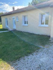 a house with a hose in front of a yard at Les 4 M in Gercourt-et-Drillancourt