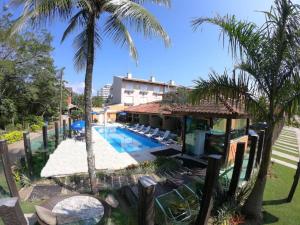 a resort with a swimming pool and palm trees at Pousada Acqua Infinity PISCINA CLIMATIZADA PÉ NA AREIA in Bertioga
