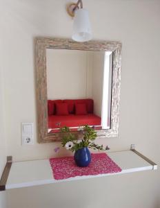 Habitación con un sofá rojo en el espejo. en Villa Perivoli, en Parga