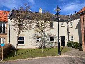 a white house with a street light in front of it at Filey Hideaway Apartment The Bay Holiday Village Filey Homesweetholidayhomes in Filey