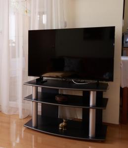 telewizor z płaskim ekranem siedzący na czarnym stojaku w obiekcie Apartman Nelamore - Krk town, 300 meters to the beach w Krku