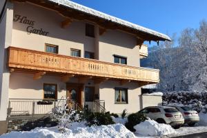 a large building with a balcony in the snow at Haus Garber in Zell am Ziller