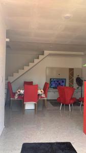 un soggiorno con sedie rosse e un tavolo con un computer di Apartamento Duplex Mobiliado em São Pedro da Aldeia a São Pedro da Aldeia