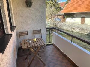Ferienwohnung im Gerberhaus في Gammertingen: طاولة خشبية وكرسيين على شرفة