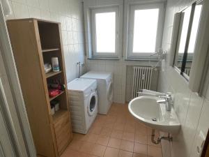 a bathroom with a washing machine and a sink at Ferienwohnung im Gerberhaus in Gammertingen +13 photos