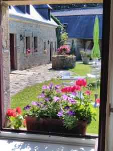 une fenêtre avec un bouquet de fleurs dans la cour dans l'établissement Domaine de Lesvaniel, à Landudec