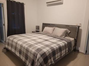 una camera con un letto con una coperta a quadri di Aquaville Dorado Moderna Villa 3 a Dorado