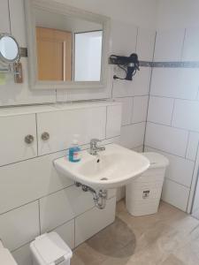 ein Badezimmer mit einem Waschbecken, einem Spiegel und einem WC in der Unterkunft Ferienwohnung Northeim City in Northeim
