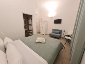 um quarto com uma cama e uma cadeira em Central Savona B&B em Savona