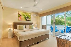 Säng eller sängar i ett rum på The Villas Palm Cove