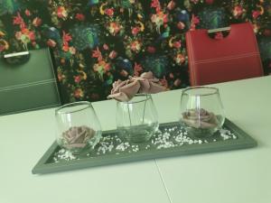 two glasses on a tray with roses in them at Ferienwohnung Northeim City in Northeim +14 photos