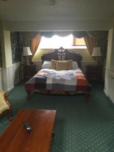 a bedroom with a bed and a table at Thelbridge Cross Inn in Crediton